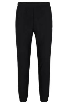 Tracksuit bottoms in stretch fabric with decorative reflective logo